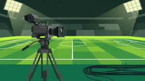 Fernsehkamera auf einem Stativ steht am Rand eines beleuchteten Spielfelds